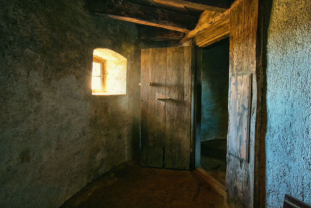 Interior de una casa vieja de pueblo, con puertas de madera y paredes rústicas